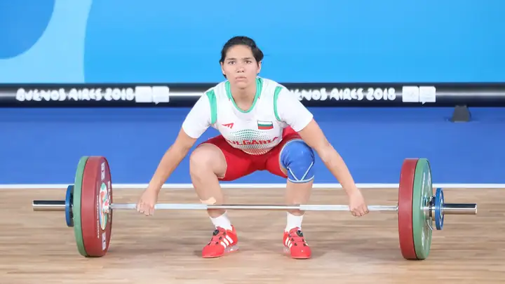 A female weightlifter grips the barbell before a snatch at the 2018 Youth Olympic Games